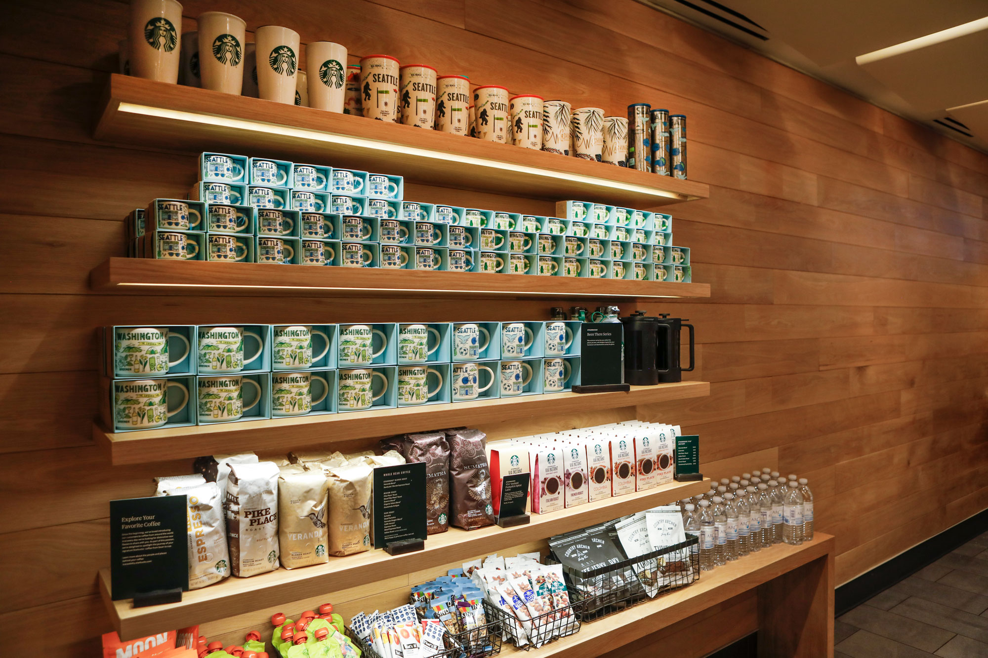 SEA Starbucks (D Gates) Interior Product Wall with Mugs and Coffee Packages
