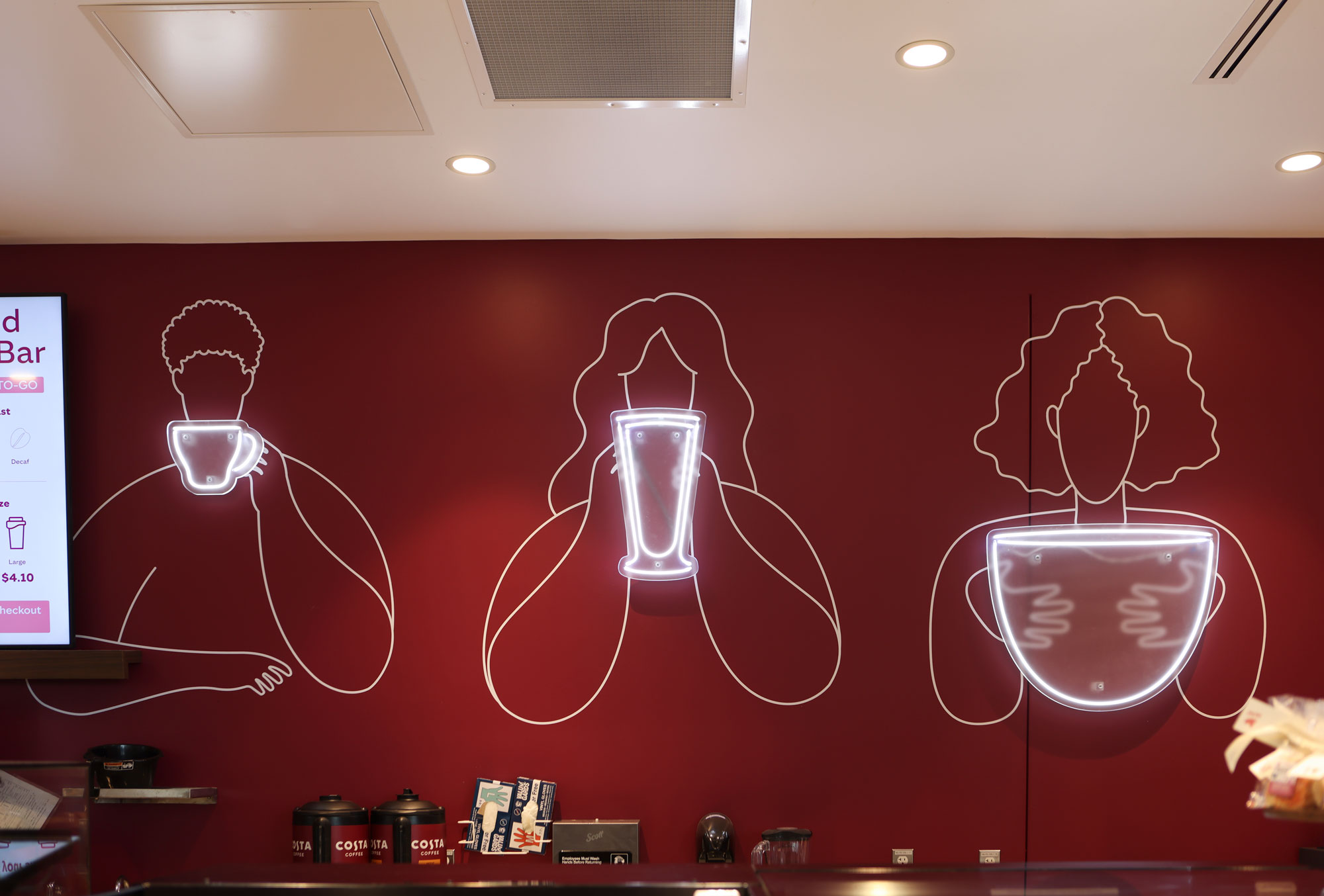 Costa Coffee design wall with 3 people drinking coffee