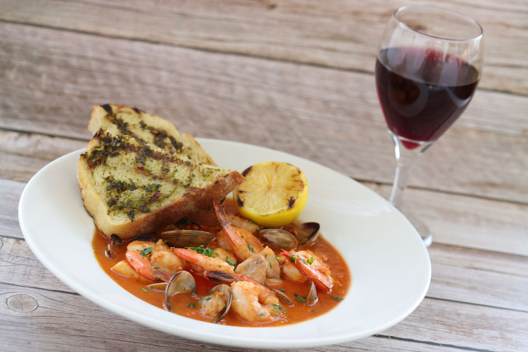 Salty's at the SEA cioppino, buttered toast, and red wine