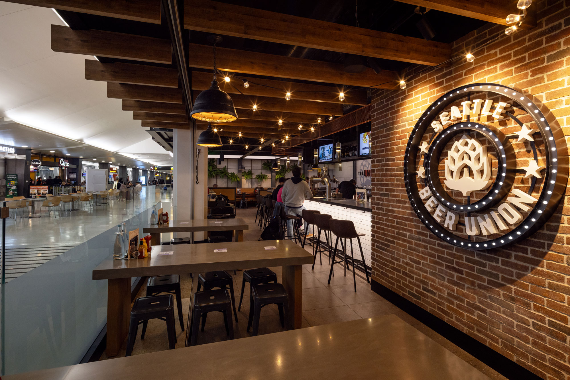 Seattle Beer Union Interior with bar seating, tables and view of terminal