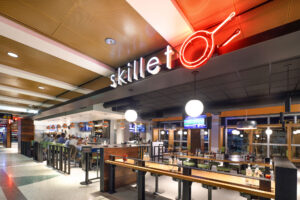 Skillet (C Concourse) exterior with travelers enjoying the bar
