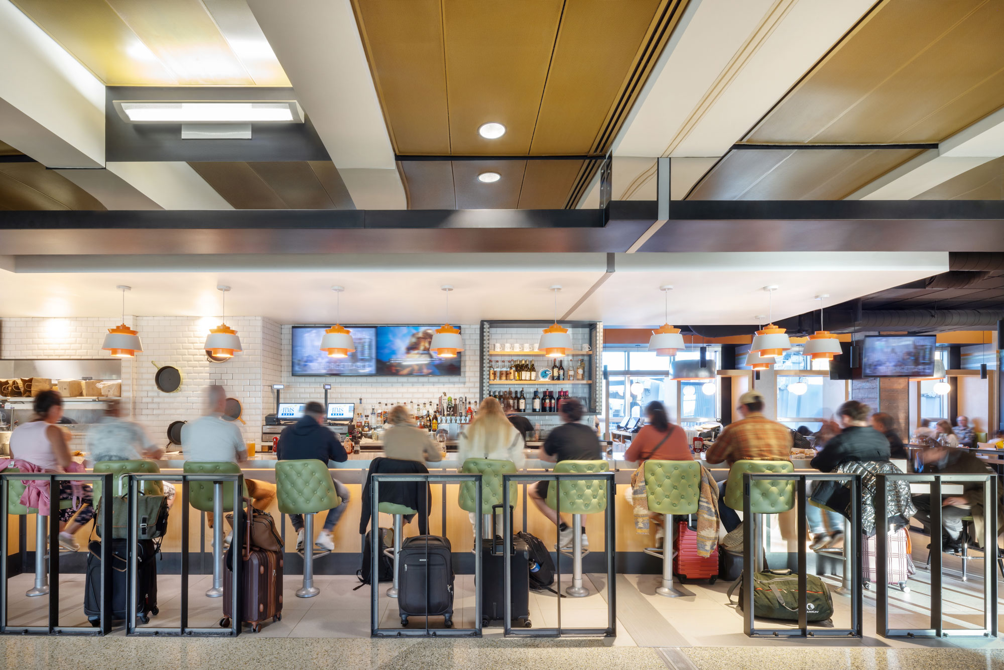 Skillet (C Concourse) with travelers at bar enjoying tv