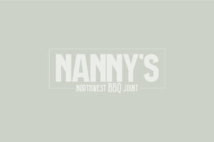 Nanny's Northwest BBQ Joint inverted white logo on green/grey background