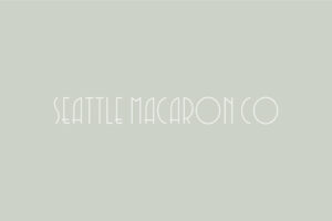 Seattle Macaron Co inverted white logo on green/grey background