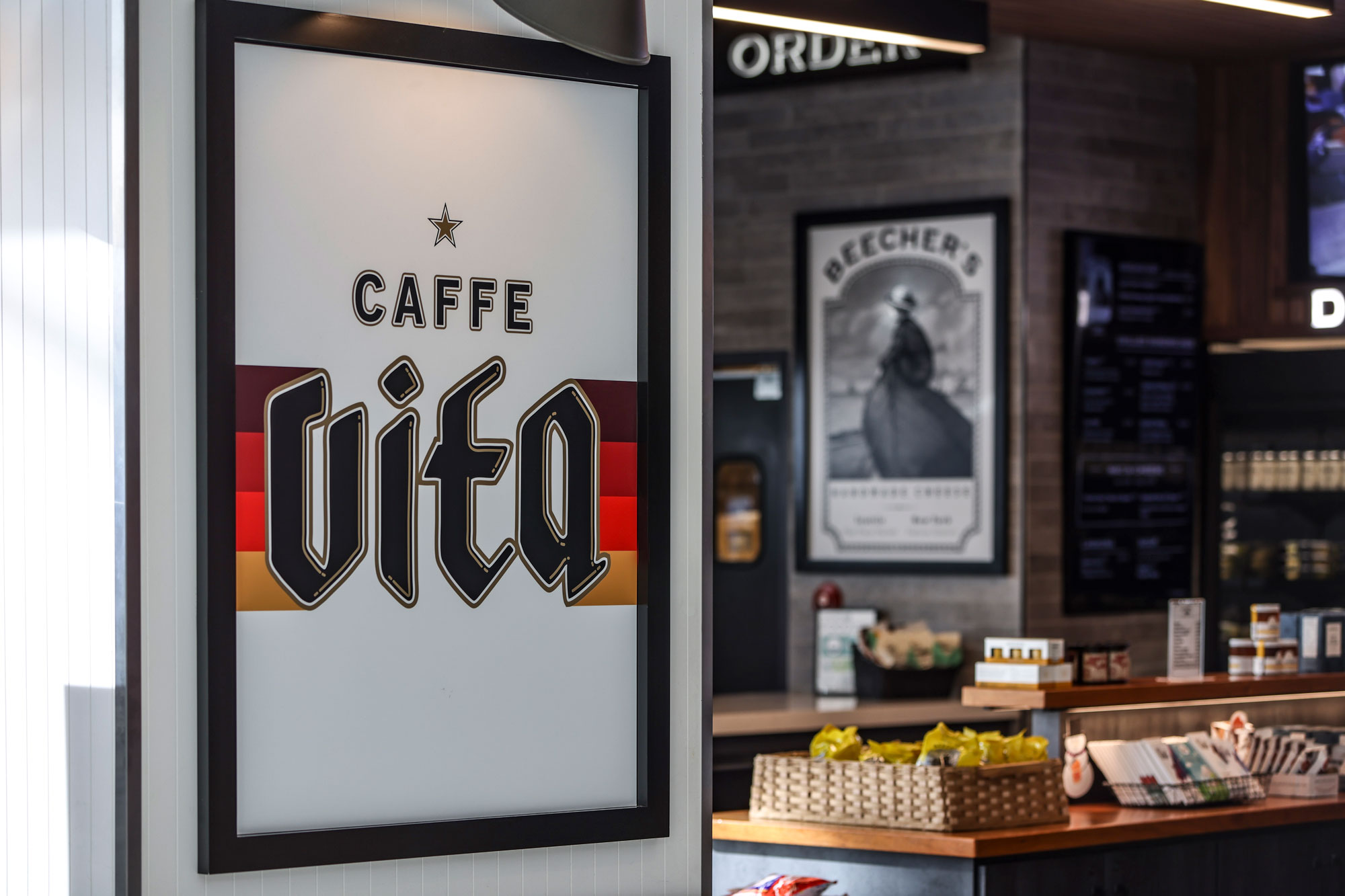 Caffe Vita framed sign with Beecher's framed sign in the background