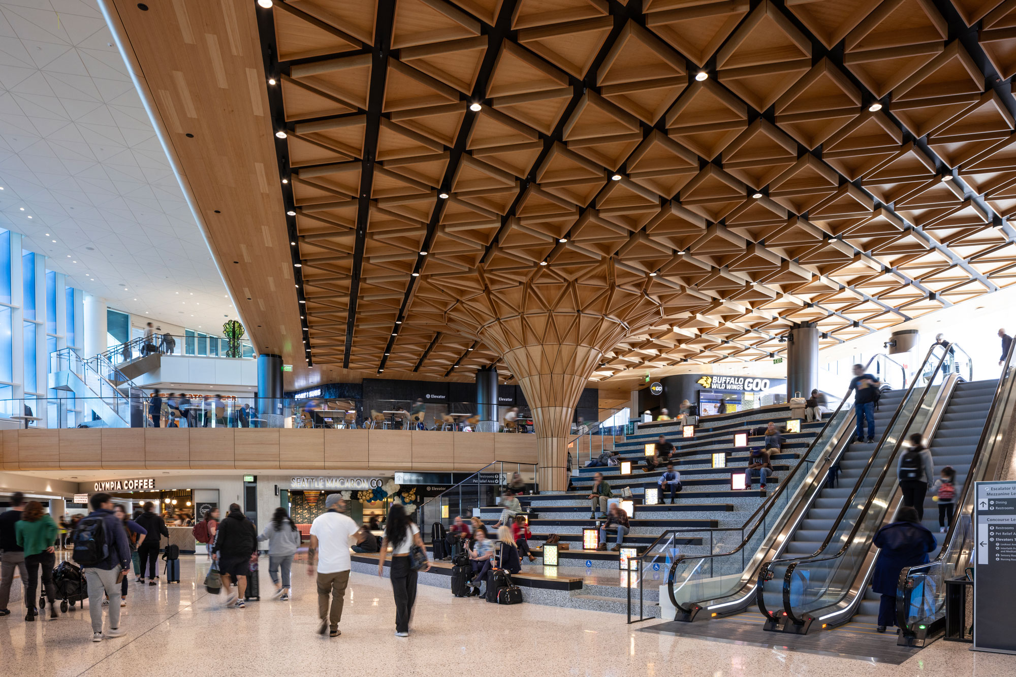 Concourse C with travelers and Seattle Macaron Co in the background