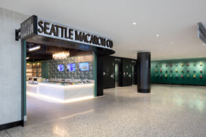 Seattle Macaron Co storefront with blade sign and "hippo" artwork in the background